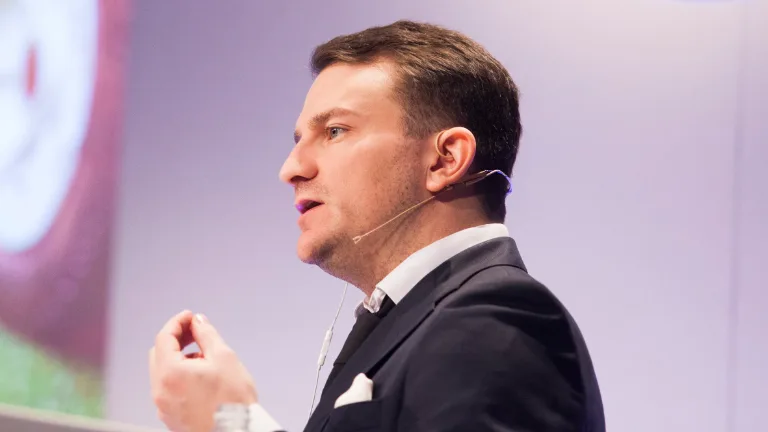 Man speaking into a headset microphone at a conference